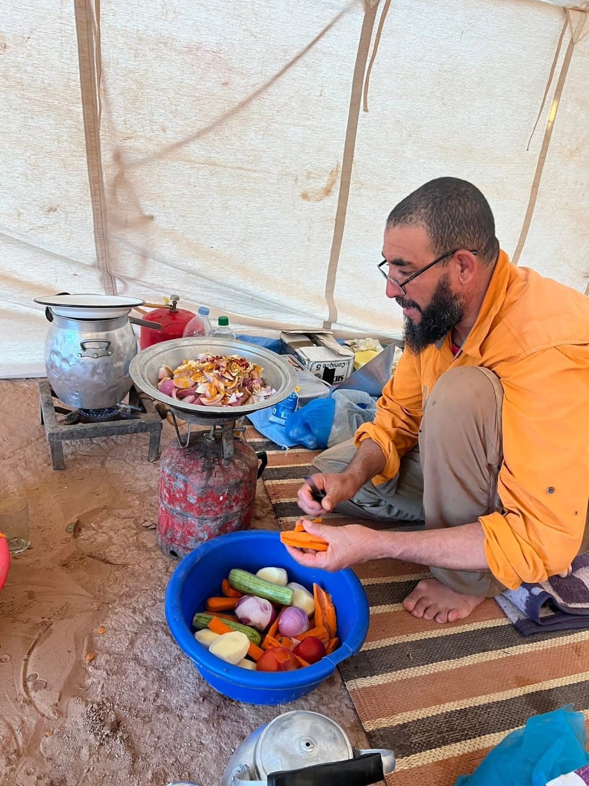 Our camp cook preparing fresh vegetables inside the mess tent on a desert departure, Morocco