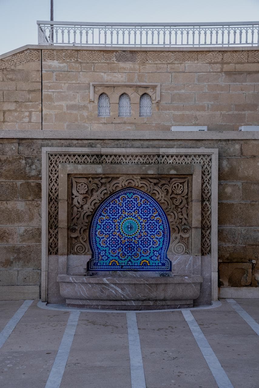 A zellij mosaic tile fountain set into a carved stone wall on the Hassan esplanade, Rabat Morocco