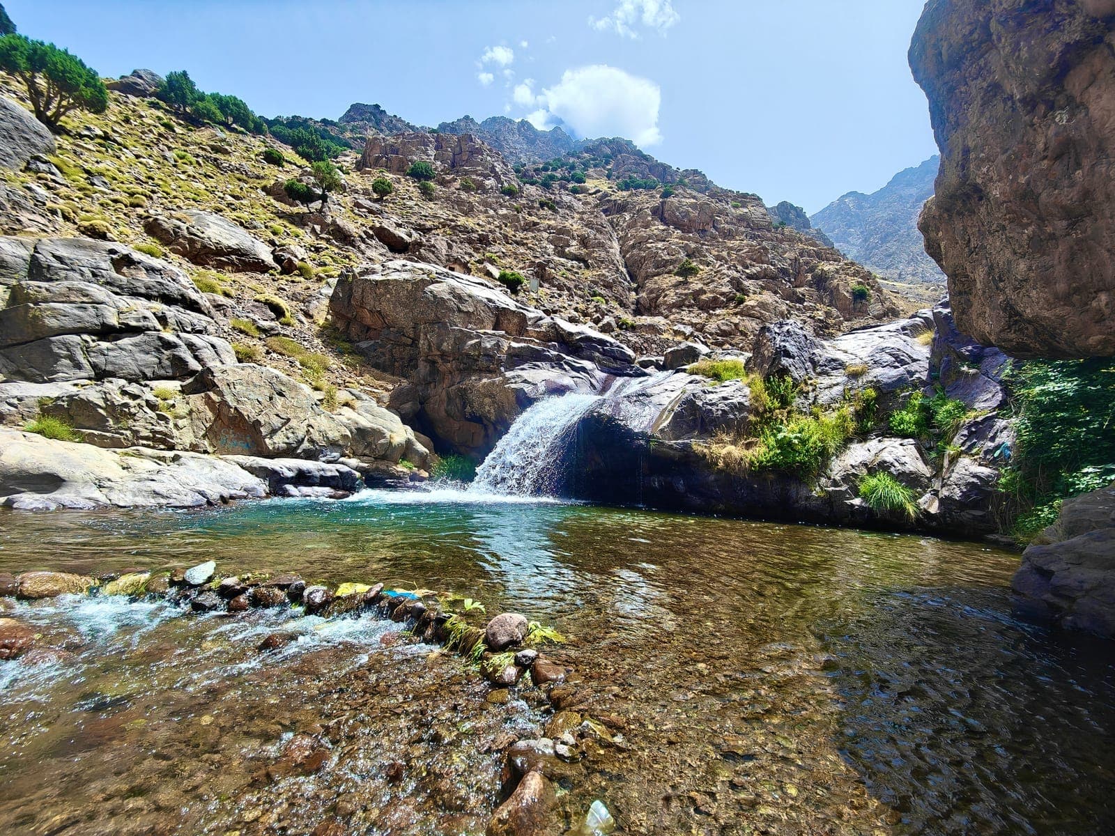 Turquoise natural pool and waterfall on the Imlil to Sidi Chamharouch trail, Toubkal, Morocco