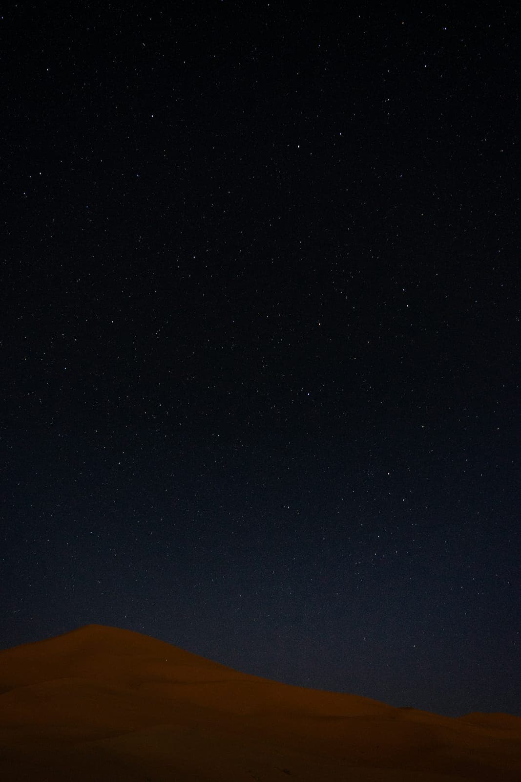 The night sky over a dune at Erg Chebbi, Merzouga — no artificial light for 50 km, Morocco